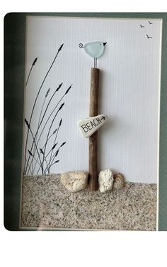 a bird sitting on top of a rock next to a wooden sign that says beach