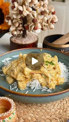 an image of food on a plate with rice and nuts in the background at a table