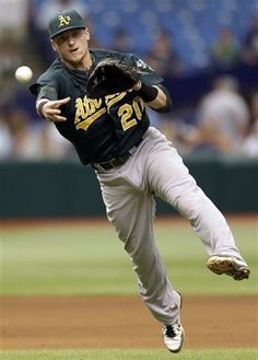 a baseball player in mid air catching a ball