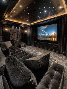 a home theater with two couches and a large screen in the middle of the room