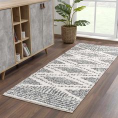 a large white rug on top of a hard wood floor next to a wooden cabinet