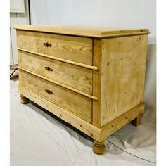 a wooden dresser sitting on top of a white sheet