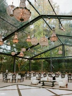 an indoor dining area with chandeliers hanging from the ceiling