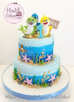 a three tiered cake decorated with blue and white frosting, under the sea theme