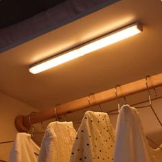 some towels hanging on a clothes rack under a light