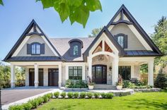 a large house with lots of windows in the front yard and landscaping on both sides