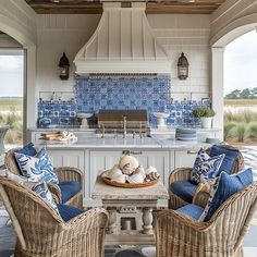 an outdoor kitchen with wicker furniture and blue tile backsplash