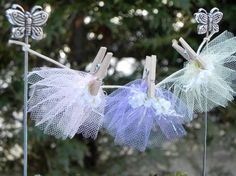 three little clothes pins with flowers and butterflies on them