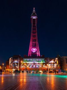 the tower is lit up in pink and purple