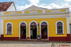 a yellow and red building with white trim