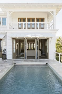 a large white house with a pool in front