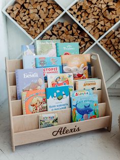 there are many books in the holder on the floor next to firewood stacked up