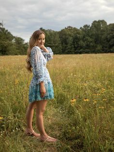 This blue botanical ruffled dress features an open back and v neck. The model is wearing a size medium. Caroline Dress, Ruffled Dress, Open Back Dresses, The Model, Nice Tops, Sale House, Clothes For Sale, High Low Dress, Open Back