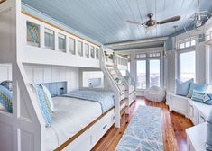 a bedroom with bunk beds and windows in the ceiling, along with a rug on the floor