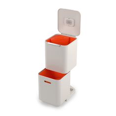 two white storage boxes with orange lids on each one and an electronic device in the other