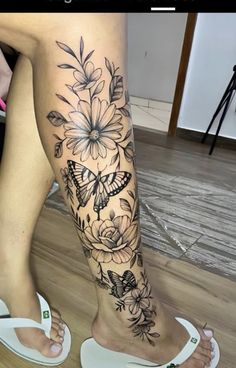 a woman's leg with flowers and butterflies on it