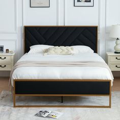 a bed with white sheets and black headboard next to two pictures on the wall