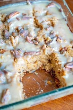 a close up of a cake in a pan with icing on the top and pecans