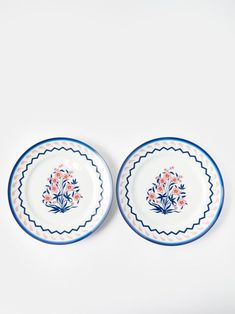 two blue and white plates sitting on top of each other, one with flowers in it