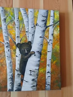 a painting of a bear peeking out from between two birch trees in the fall colors