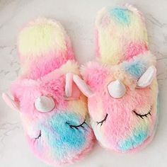 a pair of unicorn slippers on top of a marble counter