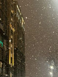 snow falling in the city at night time