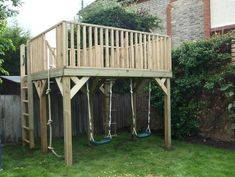 a wooden play set in the backyard with swings and ladders on it's sides