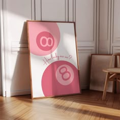 a pink and white sign sitting on top of a wooden floor next to a chair