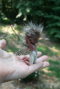 a hand holding a small toy animal in it's palm