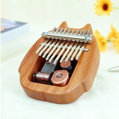 a musical instrument in a wooden case on a table with sunflowers behind it