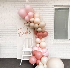 the balloon arch is decorated with pink and white balloons