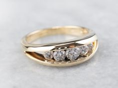 a three stone diamond ring sitting on top of a table