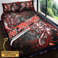 a bed room with a large window and a motorcycle comforter on top of it