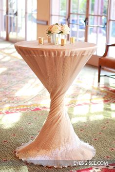 a table with candles and flowers on it in the middle of a carpeted room