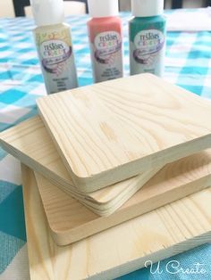 three wooden coasters sitting on top of a blue and white checkered table cloth