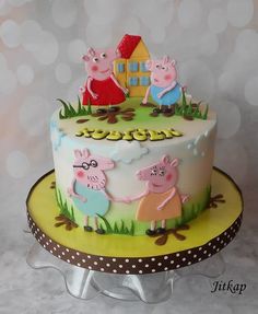 there is a cake with peppa and pig on the top it sits on a plate