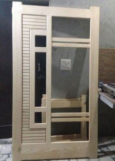 a bathroom with a wooden door and tiled flooring next to a toilet paper dispenser