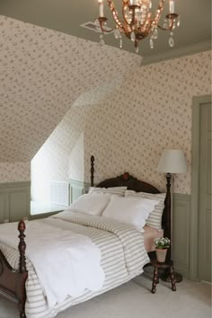 a large bed sitting under a chandelier in a bedroom