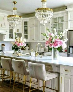 a kitchen filled with lots of white cabinets and counter top space next to a center island