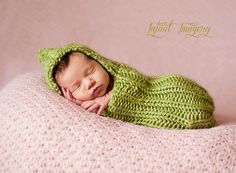 a baby wrapped in a green blanket sleeping on top of a pink blanket with the words infant imagery written above it