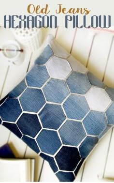 a blue and white pillow sitting on top of a wooden table next to a book