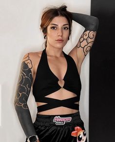 a woman with tattoos on her arms posing for the camera