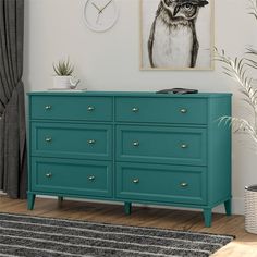 a blue dresser in a living room with a clock on the wall