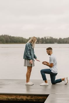 a man kneeling down next to a woman on a dock