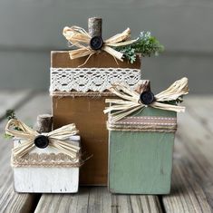 three small wooden boxes decorated with twine and lace