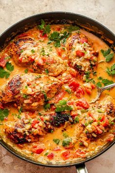 a skillet filled with chicken and tomatoes