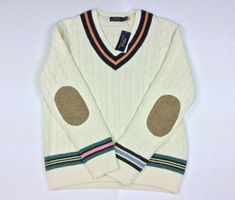 Polo Ralph Lauren Men Preppy Wool Elbow Patch Cotton Cashmere Cricket Sweater This iteration of our signature cricket sweater gets a playful update with colorful contrasting stripes. The elbows are reinforced with herringbone wool woven by Magee 1866, which has been creating authentic tweeds in Ireland for more than 150 years. Regular Fit: wider at the chest while still maintaining a modern silhouette. Sold Out, Very rare item Striped V-neck. Long sleeves with herringbone tweed elbow patches. St Casual Wool Sweater With Striped Cuffs, Cricket Sweater, Ralph Lauren Preppy, Elbow Patch Sweater, Drip Outfit Men, Evolution Of Fashion, Herringbone Tweed, Elbow Patch, Knitwear Men