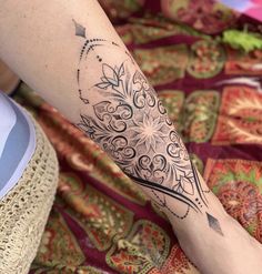 a woman's leg with a tattoo on it that has an intricate flower design