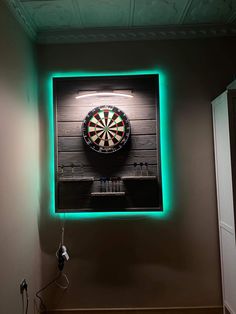 a dart board mounted to the side of a wall next to a neon green light