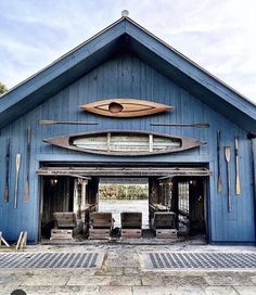 a large blue building with a surfboard on the door and two chairs in front